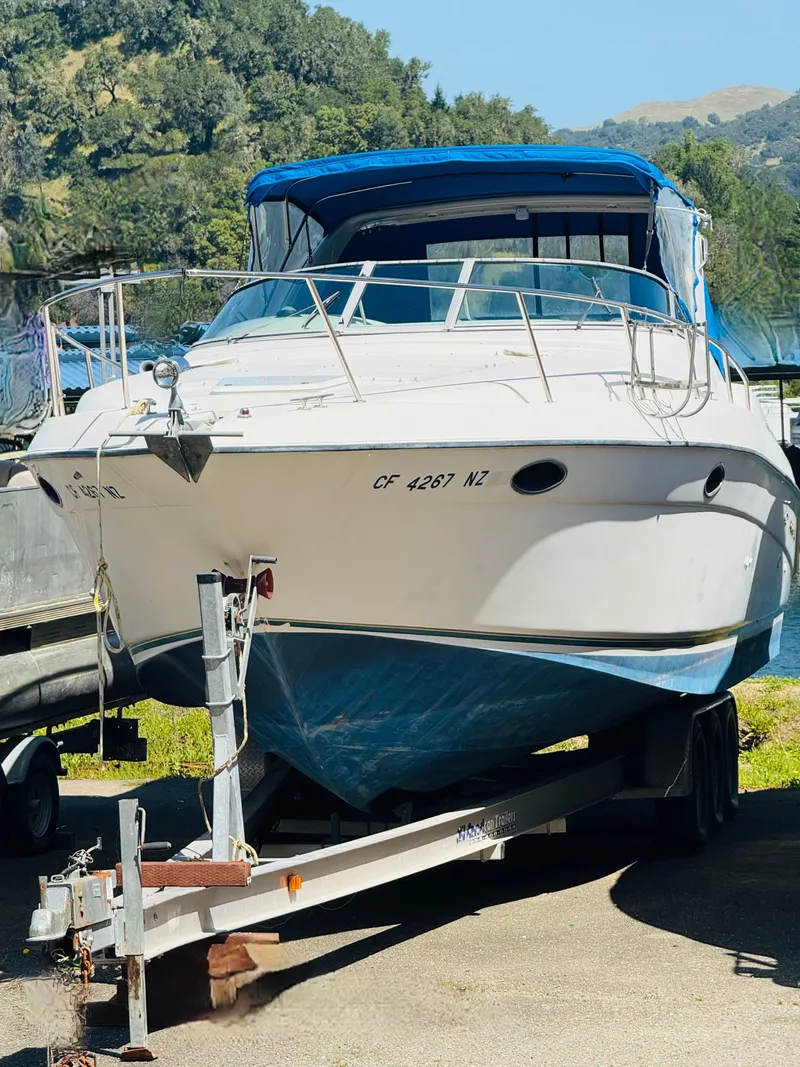 Slide: The Image of 1997 Regal 320 Commodore boat on trailer, blue canopy, parked outdoors. - 1
