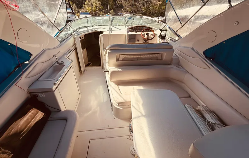 Slide: The Image of 1997 Regal 320 Commodore boat interior with seating and helm, featuring blue accents. - 10