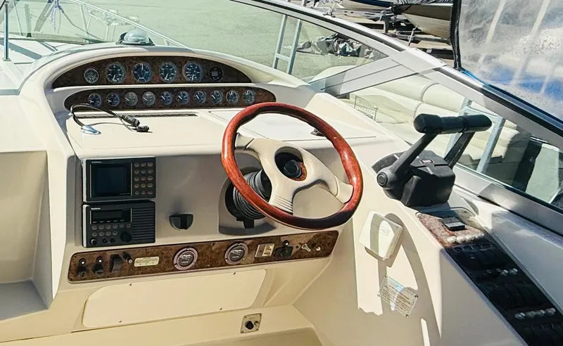 Slide: The Image of 1997 Regal 320 Commodore boat dashboard with wooden steering wheel and control panel. - 18