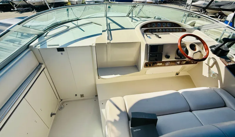 Slide: The Image of 1997 Regal 320 Commodore boat cockpit with steering wheel and seating area. - 19