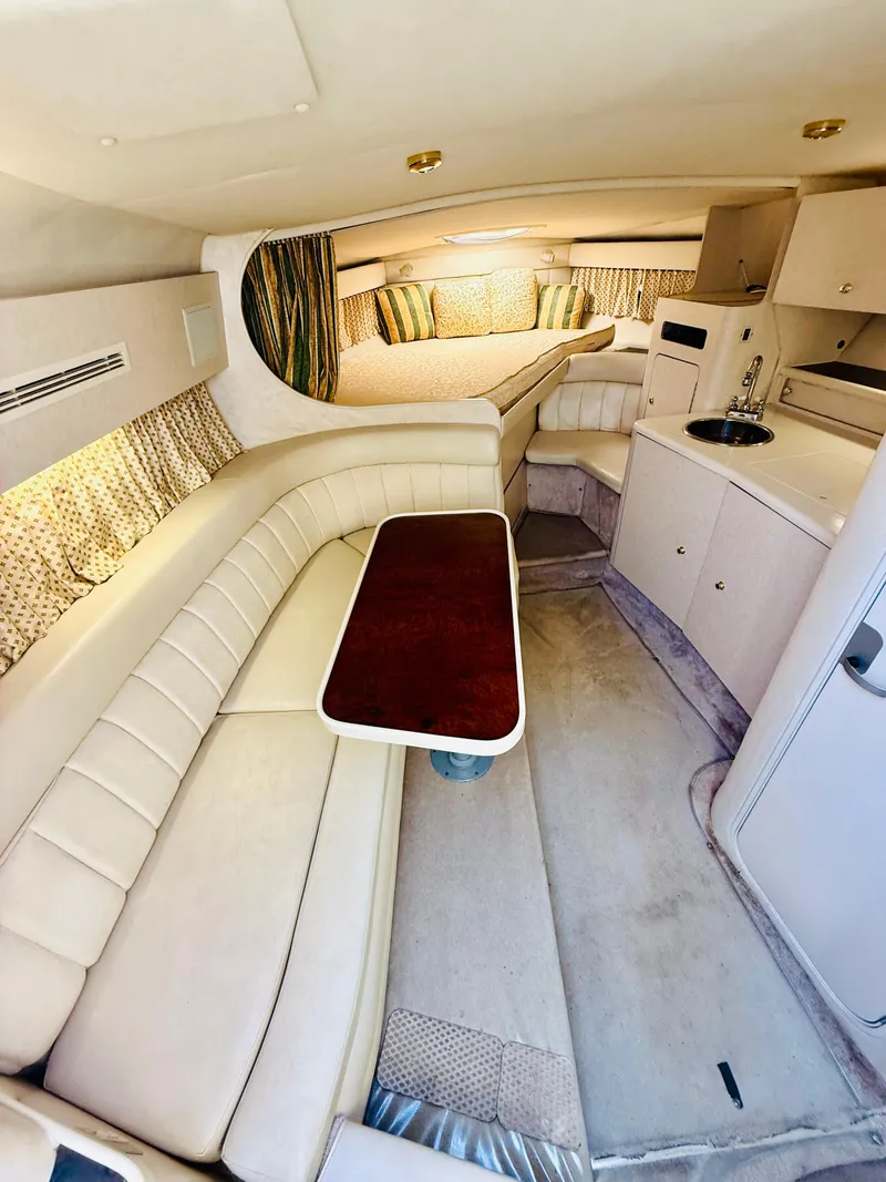 Slide: The Image of Interior of a 1997 Regal 320 Commodore yacht with seating and kitchenette. - 20