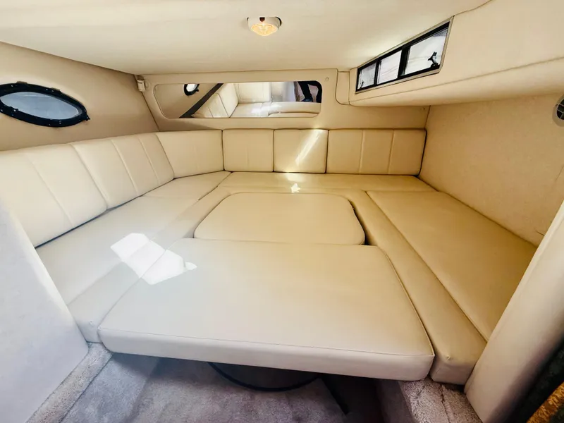 Slide: The Image of Interior cabin of 1997 Regal 320 Commodore with beige seating and windows. - 21