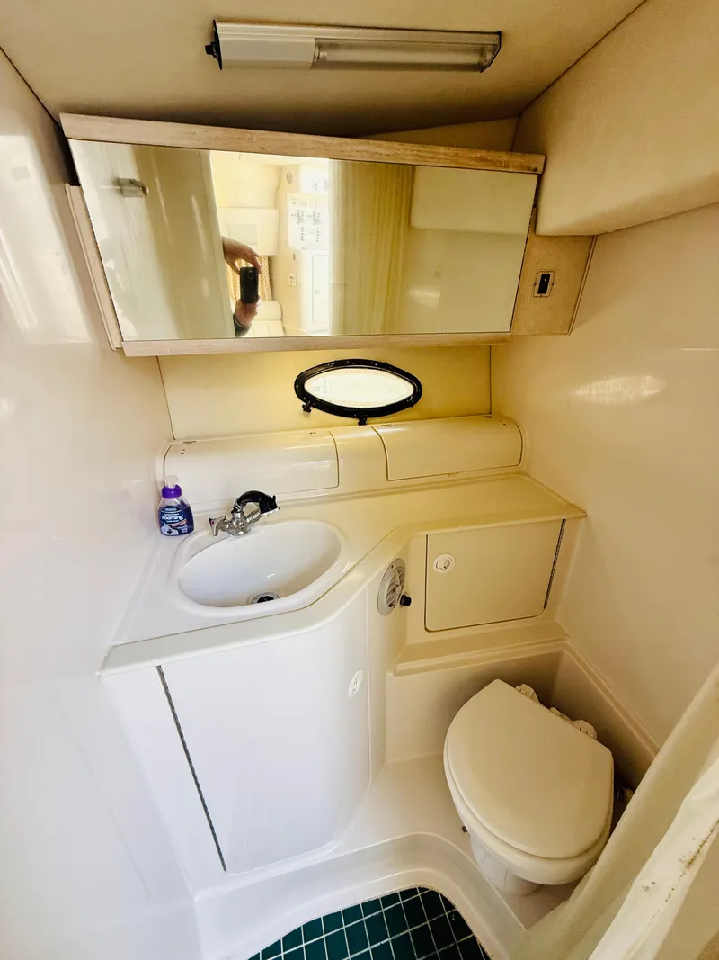 Slide: The Image of 1997 Regal 320 Commodore boat bathroom with sink, mirror, and toilet. - 22