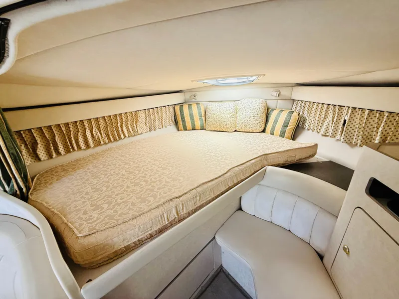 Slide: The Image of 1997 Regal 320 Commodore cabin with cozy bed and patterned cushions. - 24