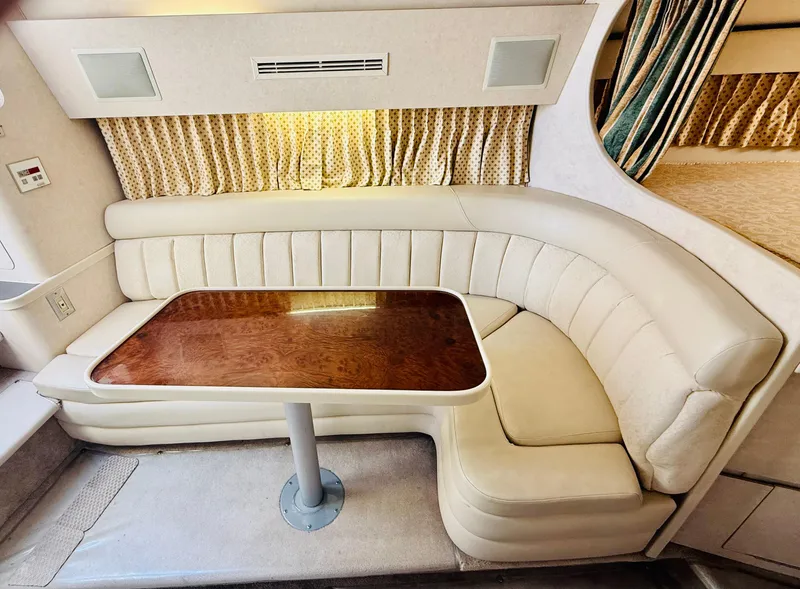 Slide: The Image of 1997 Regal 320 Commodore interior with curved seating and wooden table. - 25