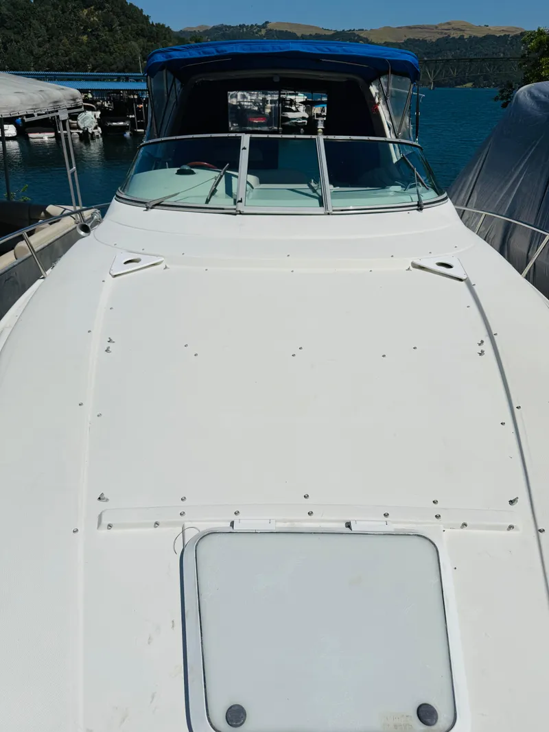 Slide: The Image of 1997 Regal 320 Commodore boat docked by a scenic lake. - 3