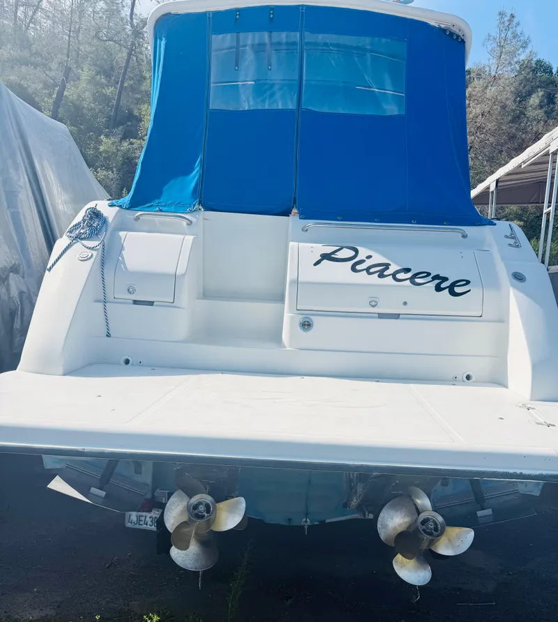 Slide: The Image of 1997 Regal 320 Commodore boat with blue canopy and dual propellers. - 6