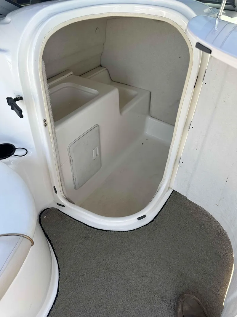 Slide: The Image of 2003 Glastron DX 235 boat interior storage compartment with carpeted flooring. - 10