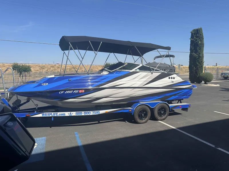 Slide: The Image of 2003 Glastron DX 235 boat with blue and gray design on a trailer. - 4