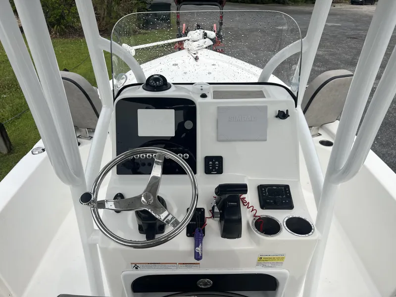 Slide: The Image of 2021 Sea Pro 228 Bay boat console with steering wheel and navigation controls. - 10
