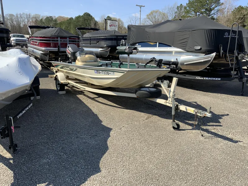 Slide: The Image of 1999 Lowe 180 boat on trailer, surrounded by other boats in a dealership lot. - 1