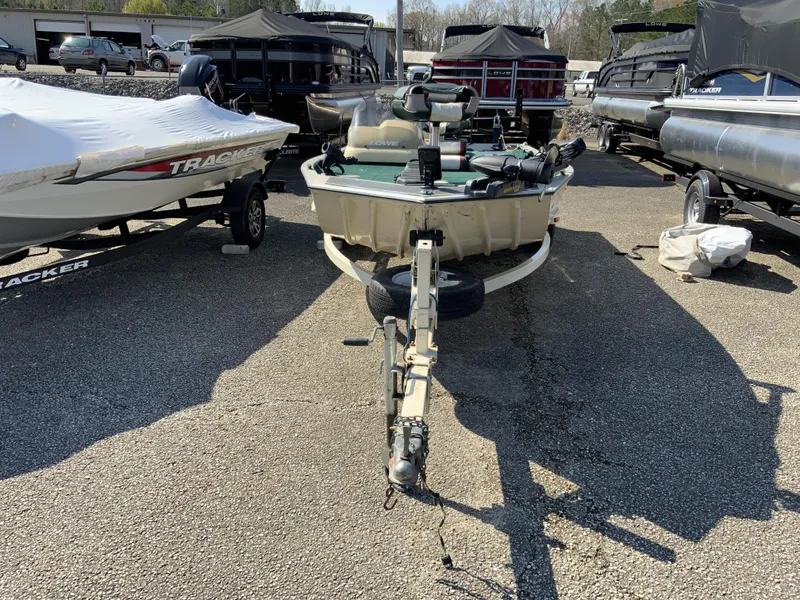Slide: The Image of 1999 Lowe 180 boat on trailer in a parking lot, surrounded by other boats. - 2