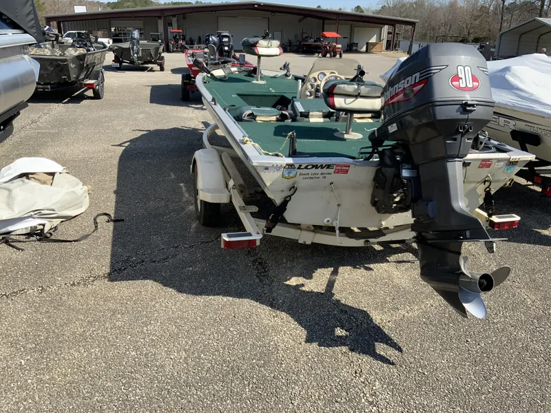 Slide: The Image of 1999 Lowe 180 boat with Johnson outboard motor in a parking lot. - 4