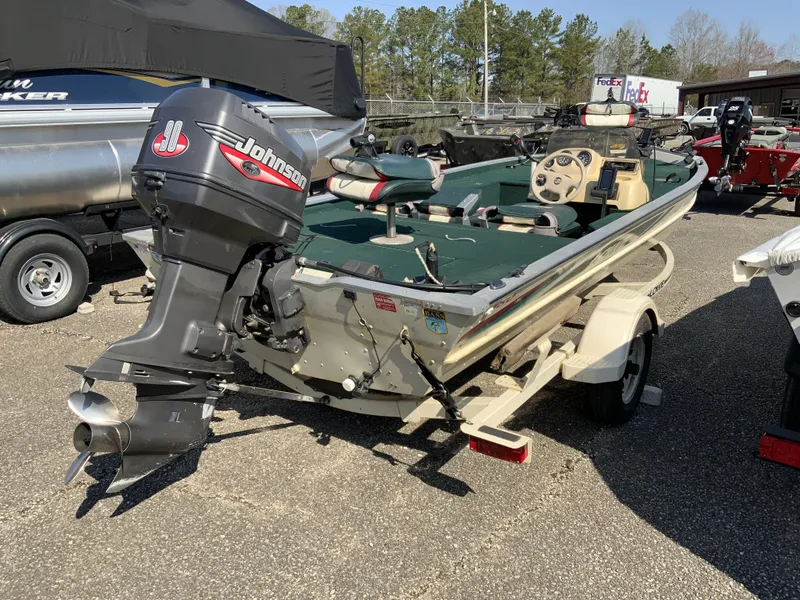 Slide: The Image of 1999 Lowe 180 boat with Johnson outboard motor on trailer, parked outdoors. - 5