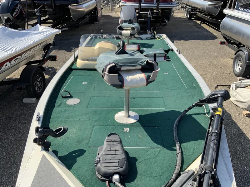 Slide: The Image of 1999 Lowe 180 boat with green deck, fishing seats, and trolling motor. - 6