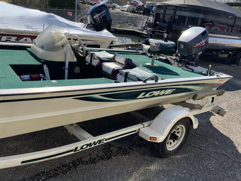Slide: The Image of 1999 Lowe 180 boat on trailer with green interior and Johnson outboard motor. - 8