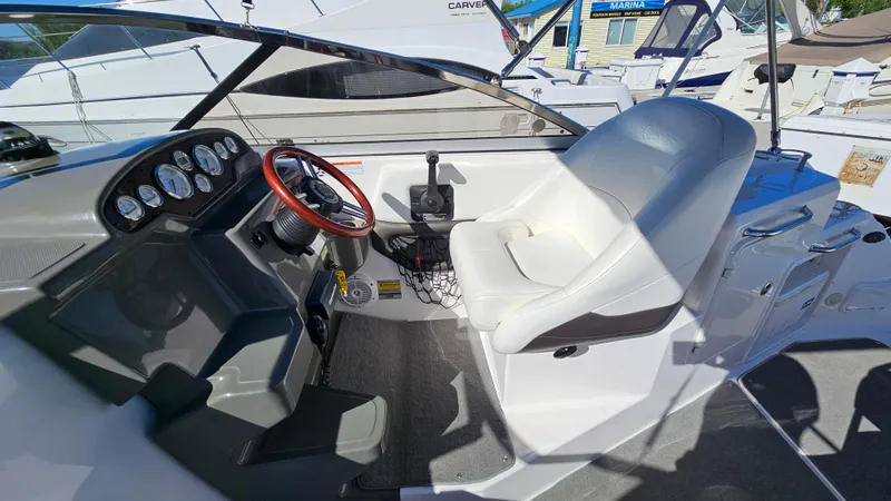 Slide: The Image of 2008 Regal 2565 Window Express boat cockpit with steering wheel and white captain's chair. - 10