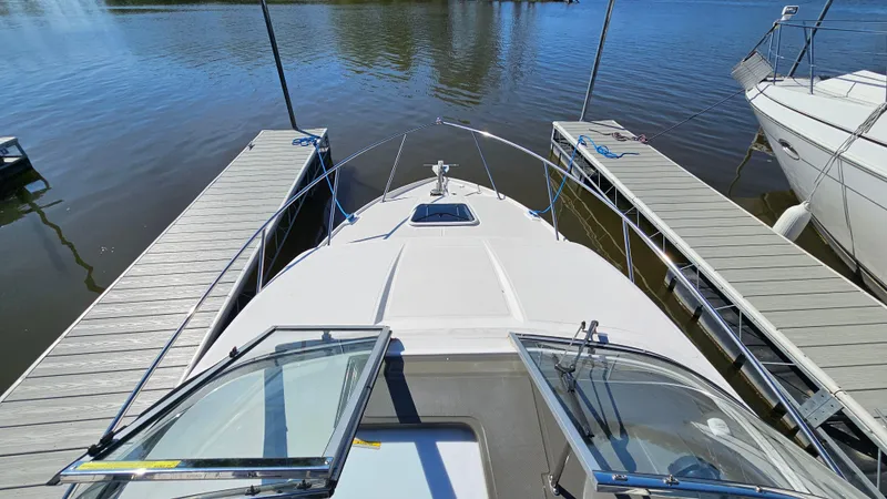 Slide: The Image of 2008 Regal 2565 Window Express boat docked between piers on calm water. - 14