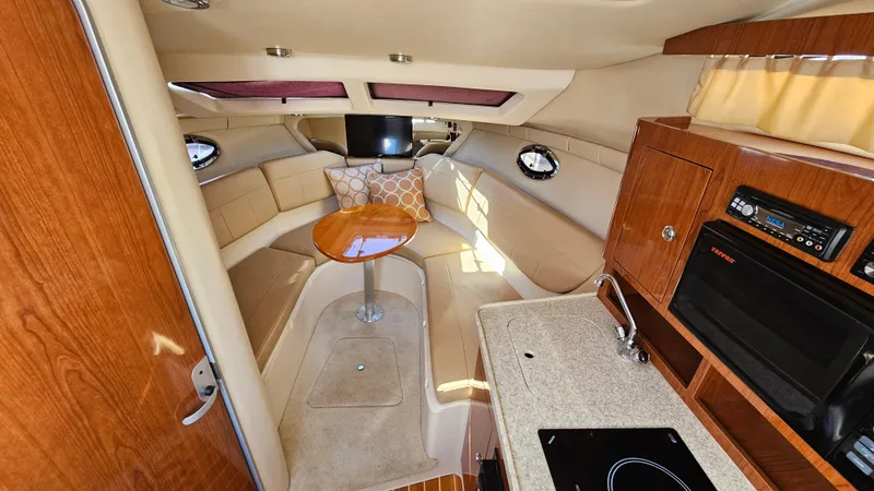 Slide: The Image of Interior of 2008 Regal 2565 Window Express boat with cozy seating and kitchenette. - 15