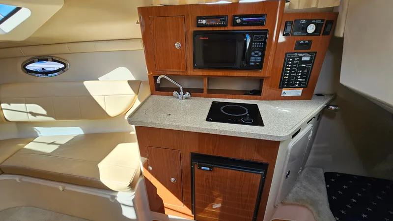 Slide: The Image of Interior of 2008 Regal 2565 Window Express boat with kitchenette and seating area. - 17