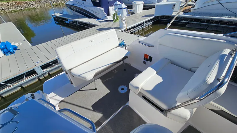Slide: The Image of 2008 Regal 2565 Window Express boat interior with white seating at a marina. - 7