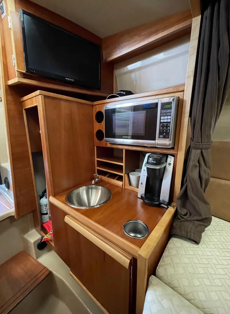 Slide: The Image of 2015 Cutwater C-28 interior kitchenette with sink, microwave, and coffee maker. - 15