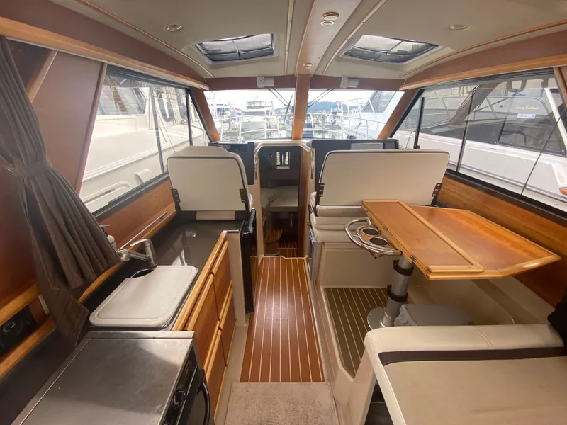 Slide: The Image of Interior of a 2015 Cutwater C-28 boat, featuring a modern cabin with wood accents. - 23