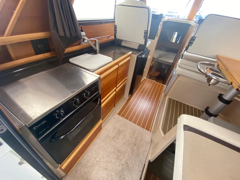 Slide: The Image of Interior of 2015 Cutwater C-28 boat featuring kitchen and seating area. - 24