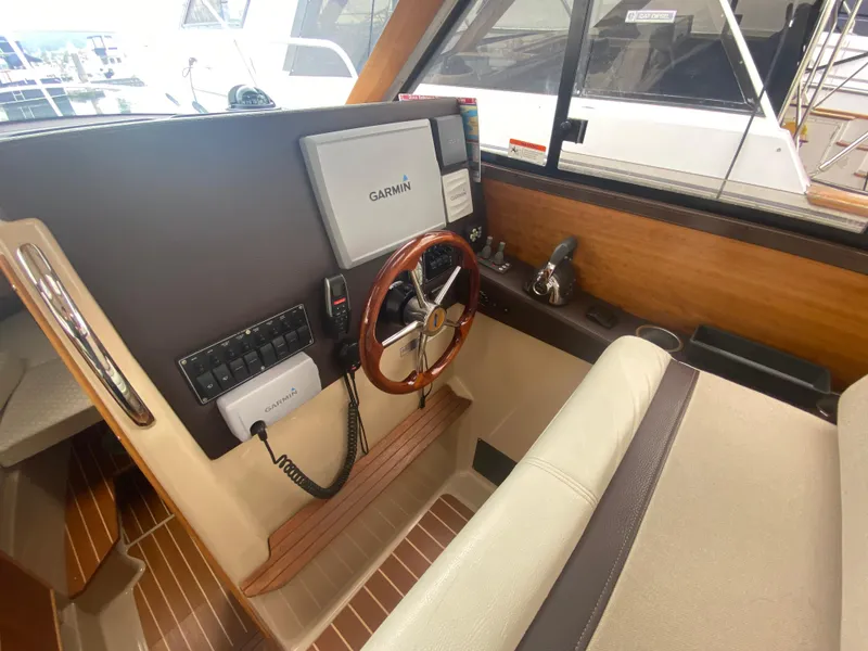Slide: The Image of Interior helm of 2015 Cutwater C-28 boat with Garmin navigation system and wooden steering wheel. - 25