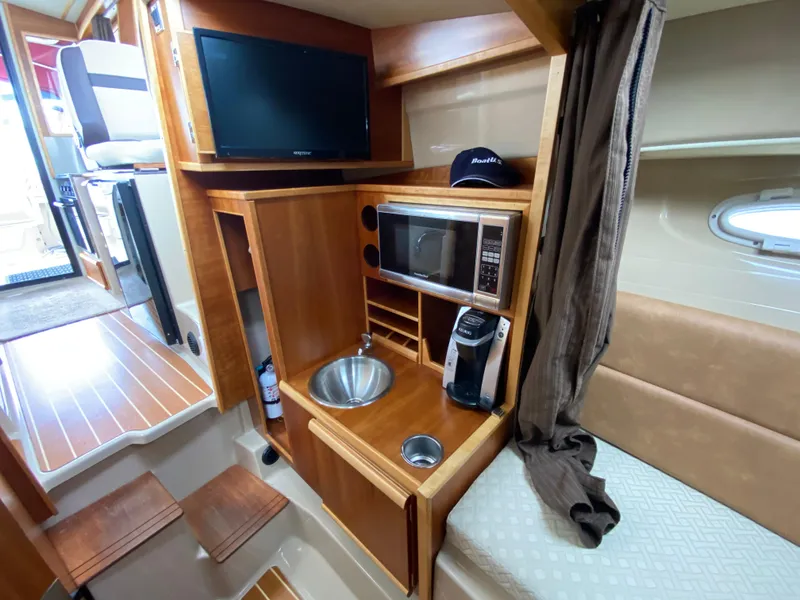 Slide: The Image of Interior of 2015 Cutwater C-28 boat with kitchenette, TV, and seating area. - 28