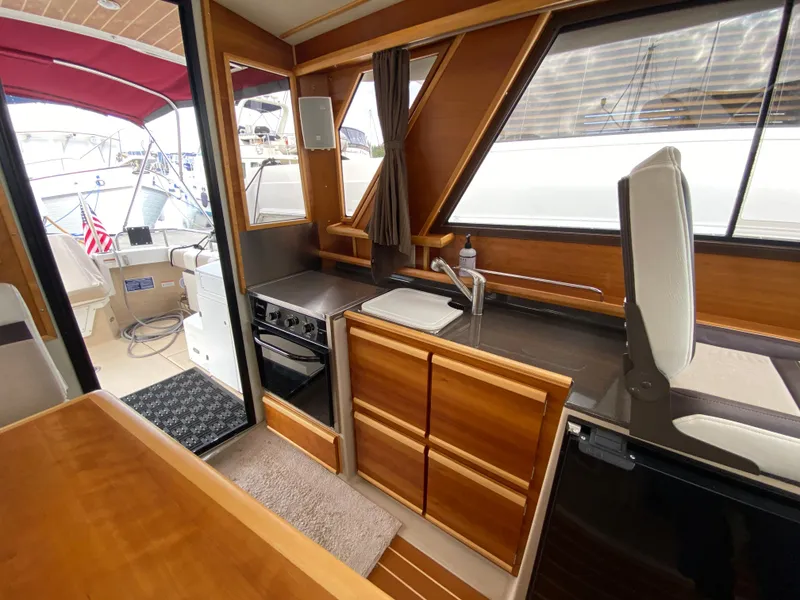 Slide: The Image of Interior of 2015 Cutwater C-28 boat with wood cabinetry and compact kitchen area. - 36