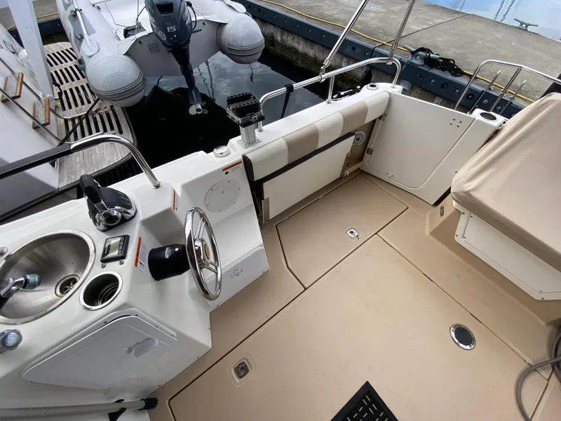 Slide: The Image of 2015 Cutwater C-28 boat cockpit with steering wheel, sink, and seating area. - 38