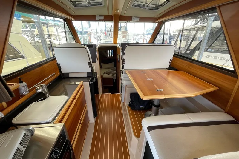 Slide: The Image of 2015 Cutwater C-28 interior with wood finish, dining table, and kitchenette. - 4