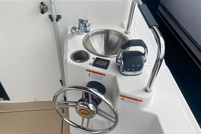 Slide: The Image of 2015 Cutwater C-28 helm with steering wheel, sink, and controls. - 41