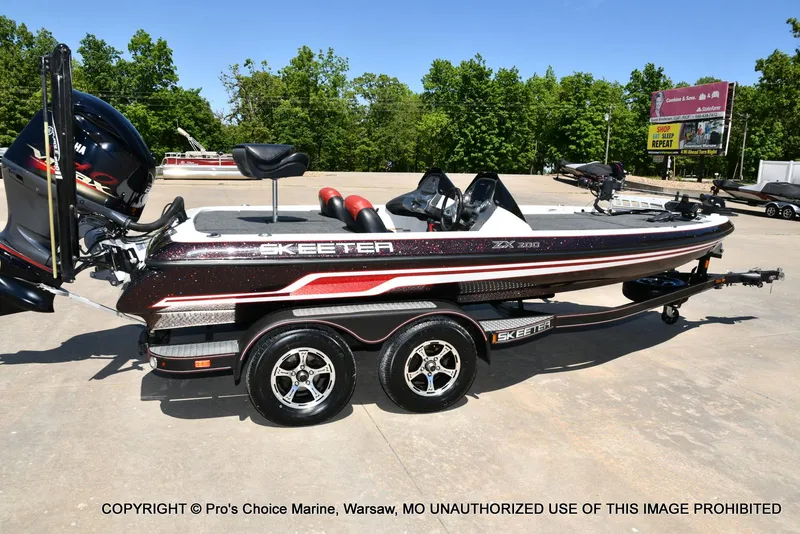 Slide: The Image of 2013 Skeeter ZX200 boat on trailer, parked outdoors, with Yamaha engine, surrounded by trees. - 15