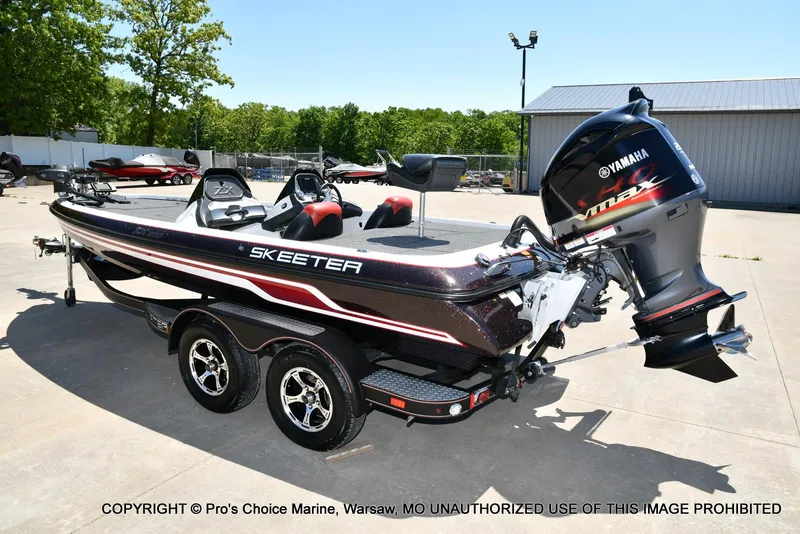 Slide: The Image of 2013 Skeeter ZX200 boat with Yamaha engine, parked outdoors on a sunny day. - 23