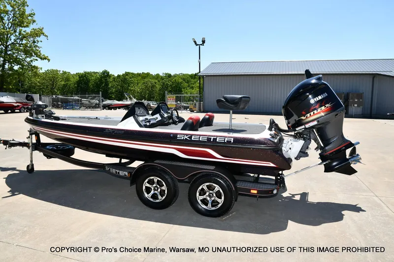 Slide: The Image of 2013 Skeeter ZX200 boat with Yamaha engine on trailer in outdoor setting. - 24