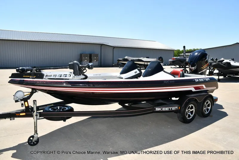 Slide: The Image of 2013 Skeeter ZX200 bass boat on trailer in outdoor storage area. - 25