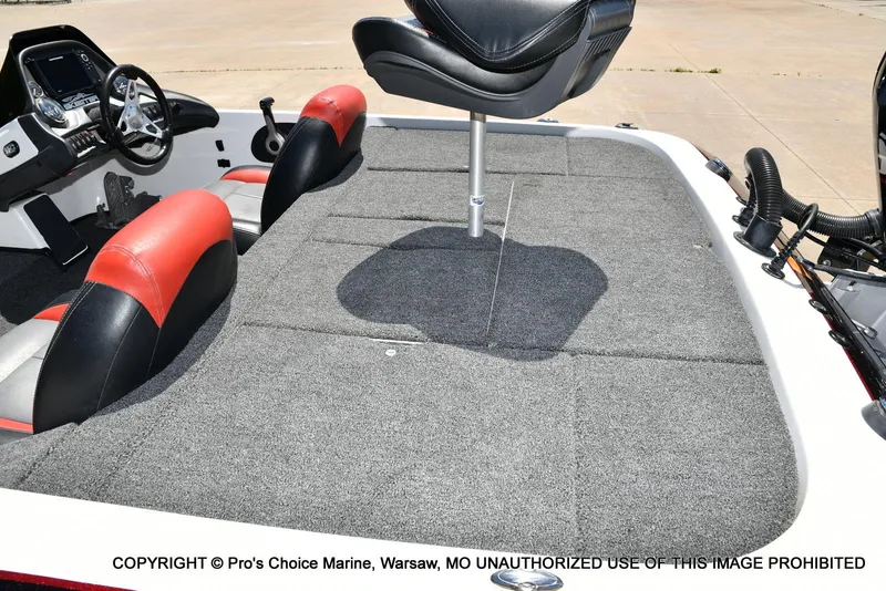 Slide: The Image of 2013 Skeeter ZX200 boat interior with red and black seats, steering wheel, and carpeted deck. - 36