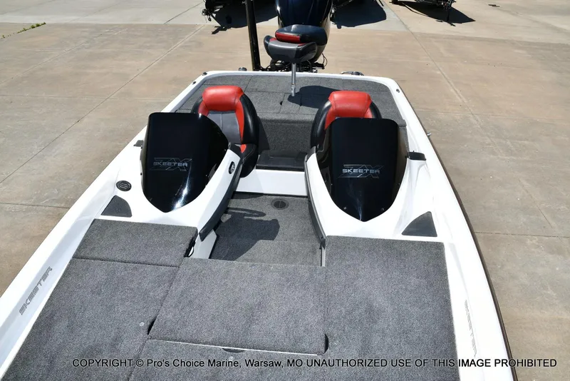 Slide: The Image of 2013 Skeeter ZX200 boat with dual seats and carpeted deck, parked on concrete. - 9