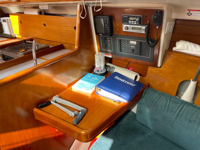 Slide: The Image of Interior of 2000 Beneteau Oceanis 321 sailboat with navigation equipment and manuals on wooden table. - 20