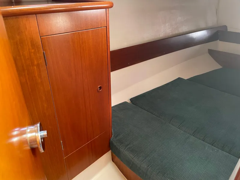 Slide: The Image of Interior cabin of 2000 Beneteau Oceanis 321 sailboat with wooden cabinet and cushioned seating. - 22