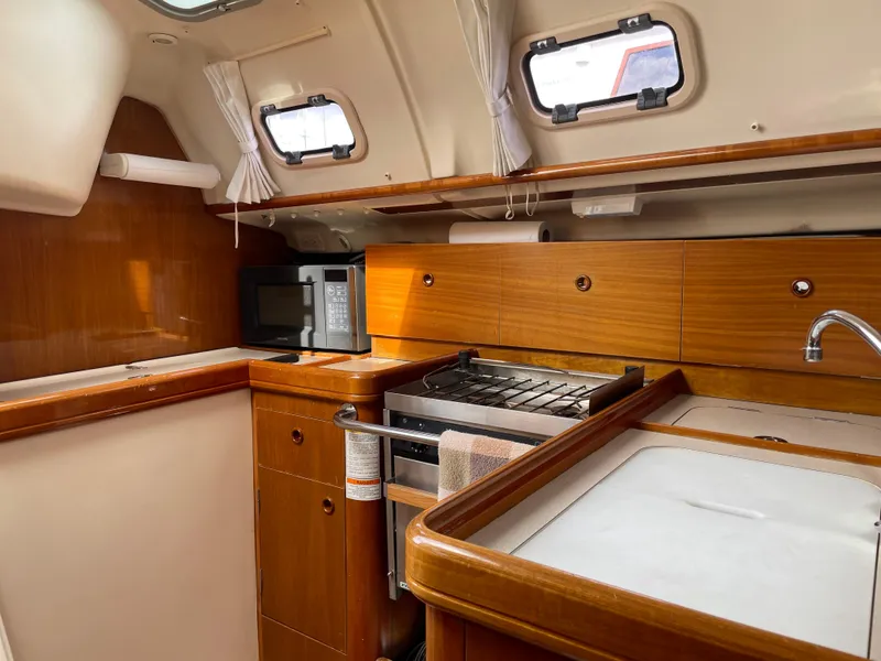 Slide: The Image of Interior of 2000 Beneteau Oceanis 321 sailboat kitchen with wood cabinetry and appliances. - 7