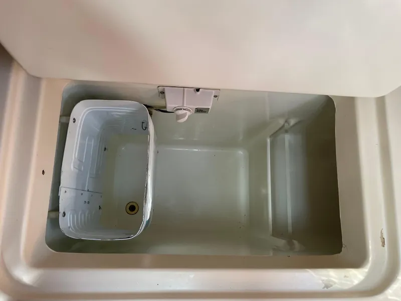 Slide: The Image of Storage compartment on a 2000 Beneteau Oceanis 321 sailboat, featuring a white container. - 9