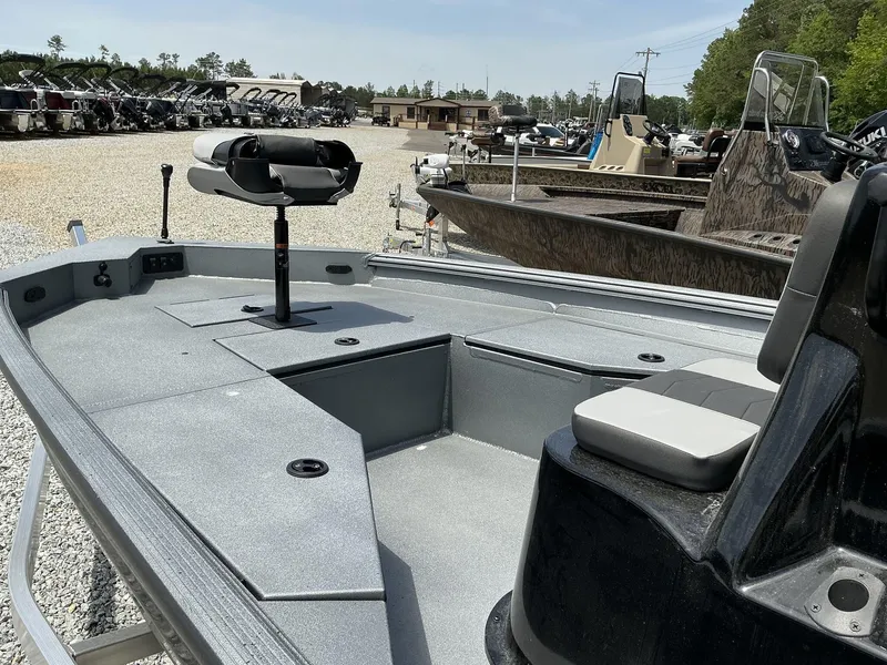 Slide: The Image of 2025 Excel Bay Pro 203 ELITE boat, gray deck, parked in a marina with other boats. - 8