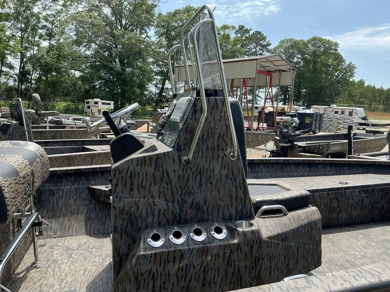 Slide: The Image of 2025 Xpress Hyper-Lift Series H22B boat with camouflage design, parked outdoors. - 10