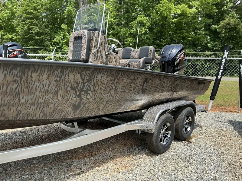 Slide: The Image of 2025 Xpress Hyper-Lift Series H22B boat on trailer, camo design, parked outdoors. - 3