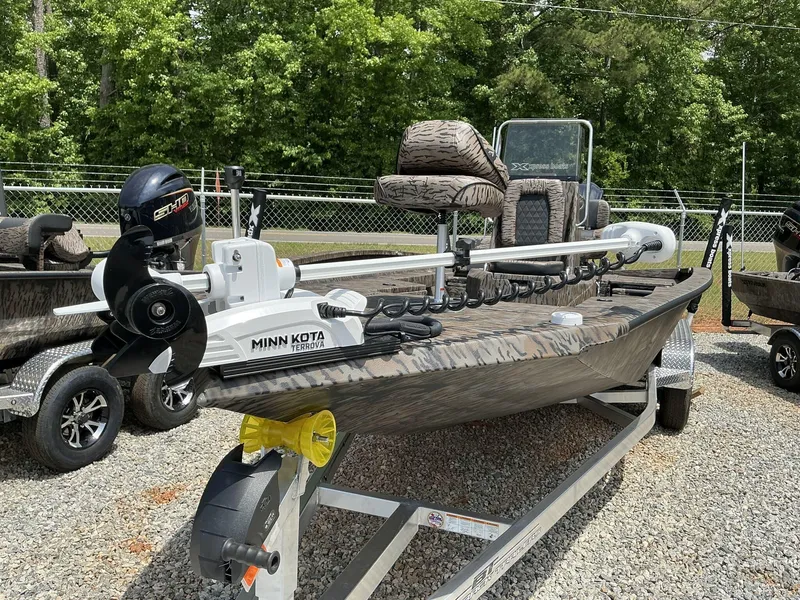 Slide: The Image of 2025 Xpress Hyper-Lift Series H22B boat with Minn Kota motor, parked on gravel. - 6