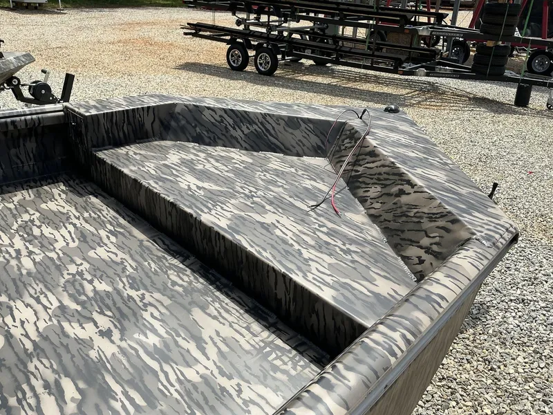 Slide: The Image of 2025 Reaper Boats 656 with camouflage pattern, parked on gravel. - 2