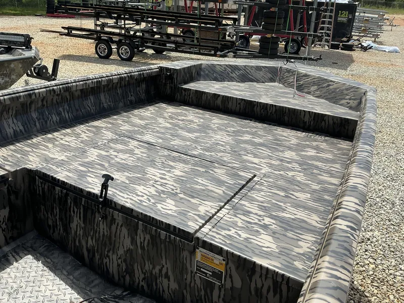 Slide: The Image of 2025 Reaper Boats 656 with camouflage design, parked on gravel lot. - 6